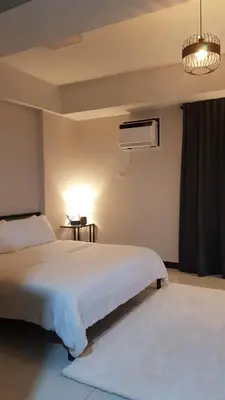 a bedroom with a large white bed and a fan at 101 Newport blvd C2 4F by Rechelle Nunag in Manila
