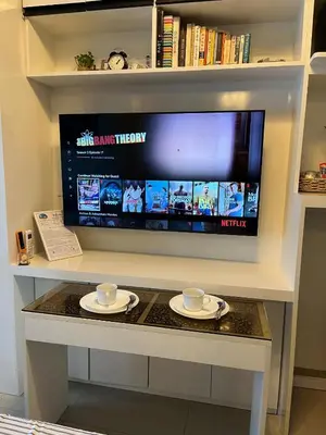 a tv on a table with two cups and plates at Overnight @ Shakhbot's in Manila