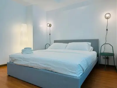 a bedroom with a large bed with white sheets and pillows at Avant at the Fort by Urban Realty in Manila