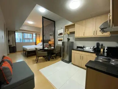 a kitchen with a living room and a bedroom at Avant at the Fort by Urban Realty in Manila