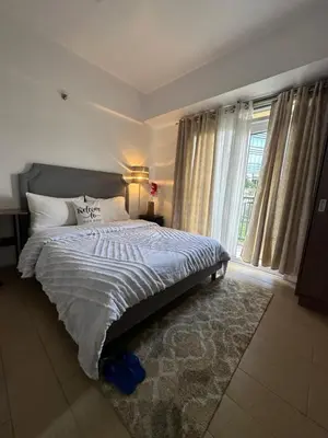 a bedroom with a large bed and a window at Cecillian place staycation @ pasay in Manila
