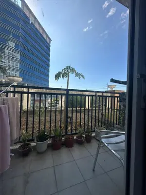 a balcony with potted plants and a palm tree at Cecillian place staycation @ pasay in Manila