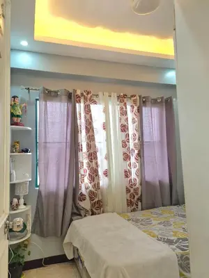 a bedroom with purple and white curtains and a bed at Afffordable Transient Ortigas Extension in Cainta