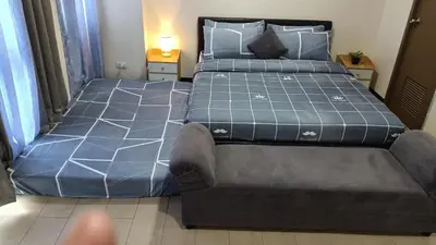 a bedroom with a large bed and a couch at Hilanders Condotel in front of Terminal 3 in Manila