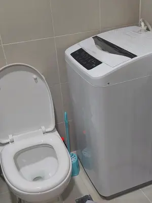 a white toilet with a book on top of it at MOA staycation by Elsie D in Manila