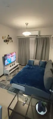 a bedroom with a large blue bed and a tv at Condo for Families and Friends in Manila