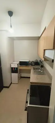 a kitchen with a sink and a stove top oven at Condo for Families and Friends in Manila