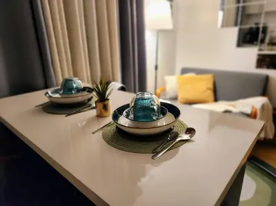 a table with two plates and spoons on it at Amari Homestay @ Sorrento Oasis Condominium in Manila