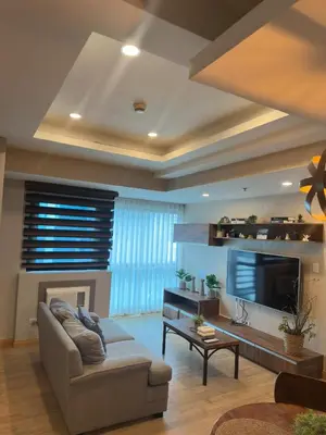 a living room with a couch and a tv at Exquisite Stays Private 2BR Rental in Manila