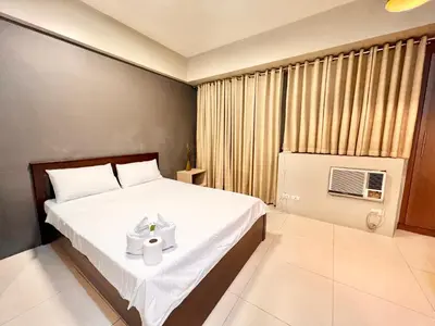 a bedroom with a bed with a white towel on it at Kiel 5-Star Condo Hotel Across NAIA Manila Airport Terminal 3 in Manila
