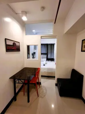 a room with a table and a chair and a bed at Makati Poblacion Hotel in Manila