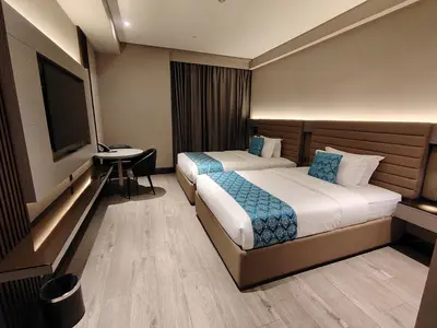 a hotel room with two beds and a flat screen tv at Bayprime Hotel in Manila