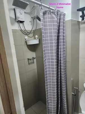 a shower with a shower curtain in a bathroom at SMDC Shore 2 Minimalist Home in Manila