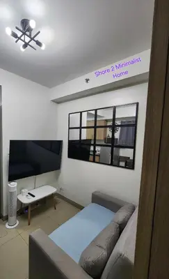 a living room with a couch and a flat screen tv at SMDC Shore 2 Minimalist Home in Manila