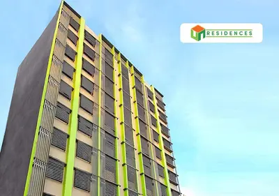 a tall building with yellow windows on the side of it at UN Residences in Manila