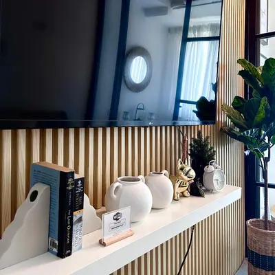 a shelf with vases and books on it at Evan Suite S Residences T1 in Manila