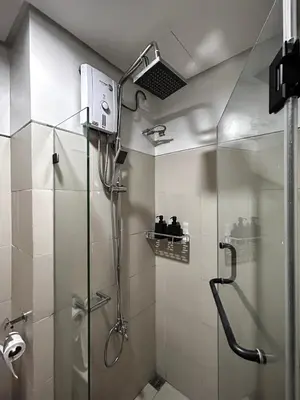 a shower with a glass door in a bathroom at Evan Suite S Residences T1 in Manila