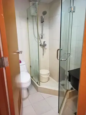 a bathroom with a toilet and a glass shower at 1BR Condo at Montecito Newport City Residential Resort across NAIA and Marriott Hotel in Manila