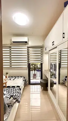 a bedroom with a bed and a desk and a window at Mall of Asia Shore 2 Condo in Manila