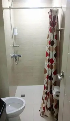 a bathroom with a shower with a toilet and a sink at Pasay Condotel near NAIA terminal 3 (3 mins walk in) in Manila