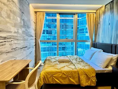 a bedroom with a bed and a large window at Grand Deluxe 3BR with Bathtub in Uptown BGC in Manila