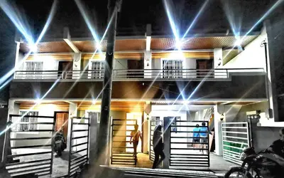 a man standing in front of a building at night at Budget Accomodation in San Pablo City Laguna in Manila