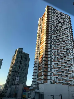 a tall building in a city with two other buildings at Staycation by JAR - Condo Unit in Manila