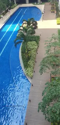 a large blue swimming pool with palm trees in it at Jejo Suite Home Shore 3 Residences Staycation 1 BR Unit Near MOA with Netflix and Prime Video in Manila