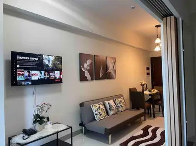 a living room with a couch and a table at Luxe 1BR w/ Balcony @ Uptown Parksuites in Manila