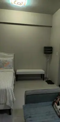 a room with a bed and a bench in it at Palm Tree Villas in Manila