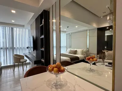 a kitchen and living room with a table with fruit on it at Uptown Parksuites BGC in Manila