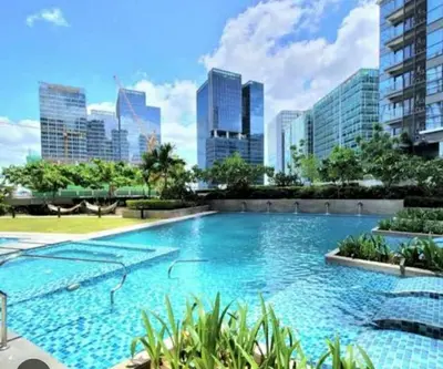 a large swimming pool with a city skyline in the background at Uptown Parksuites BGC in Manila