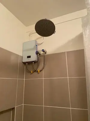 a shower in a bathroom with a light on the wall at Prisma Residences - Celeste Bldg in Manila