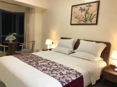 a bedroom with a bed and a table with a chair at Partial Ocean View Opposite the US Embassy in Manila