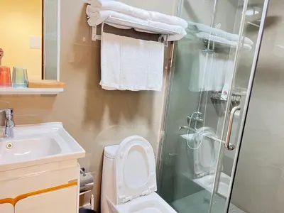 a bathroom with a shower and a toilet and a sink at Partial Ocean View Opposite the US Embassy in Manila