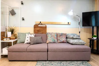 a couch with pillows on it in a living room at 12e Spacious Cozy Suite at The Venice Mall with FREE Parking and Washing Machine in Manila