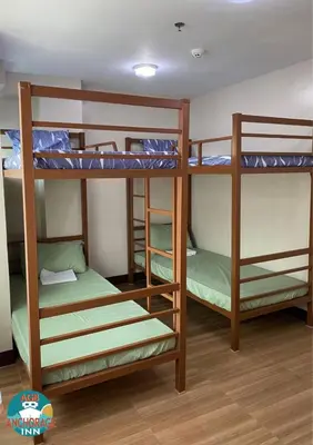 a bunk bed room with three bunk beds in it at AGB Anchorage Inn, male dorm in Manila