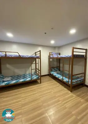 three bunk beds in a room with a wooden floor at AGB Anchorage Inn, male dorm in Manila