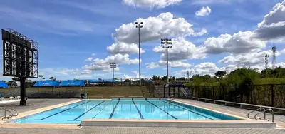 a large swimming pool with a cloudy sky at Athlete's House in Imus