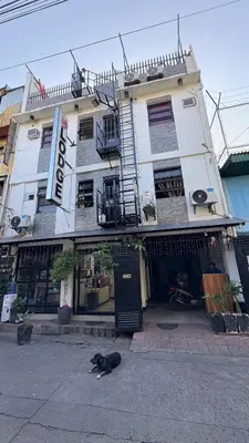 a black dog laying in front of a building at SB LODGE TAGUIG in Manila