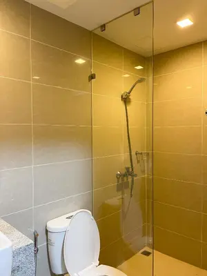 a bathroom with a toilet and a glass shower at Cityscape View 2BR in Uptown BGC w 200mbps WiFi in Manila