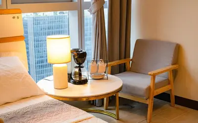 a bedroom with a bed and a table and a chair at Cityscape View 2BR in Uptown BGC w 200mbps WiFi in Manila