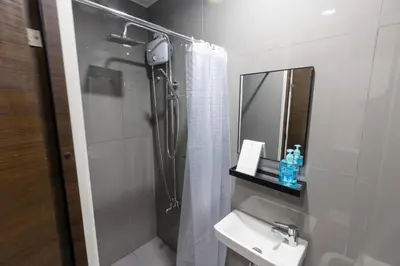 a bathroom with a shower and a sink and a mirror at Royal Victorian Studio in Makati in Manila