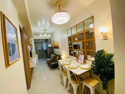 a dining room with a table and a living room at S Residences Condo PoolView Balcony in SM MOA near NAIA in Manila