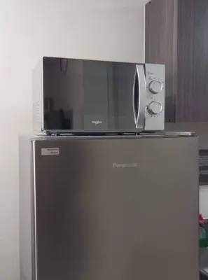 a microwave sitting on top of a refrigerator at Lovely 1 bedroom at Vista Shaw Residences in Manila