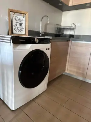 a washing machine in a kitchen with a sink at BGC, Luxe McKinley Condo at Venice Residences, Free Parking and WiFi in Manila