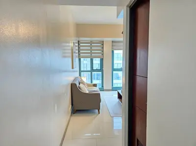 a living room with a chair and a window at One Uptown BGC Modern & Spacious, Great Location, 200mbps & washer in Manila