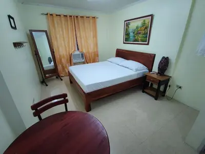 a bedroom with a bed and a chair and a mirror at Lawton Residences Studio Room 3H in Manila