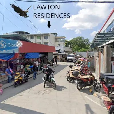 a bird is flying over a street with motorcycles at Lawton Residences Studio Room 3H in Manila