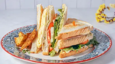 a sandwich and french fries on a plate at Starlight Bed and Breakfast in Manila